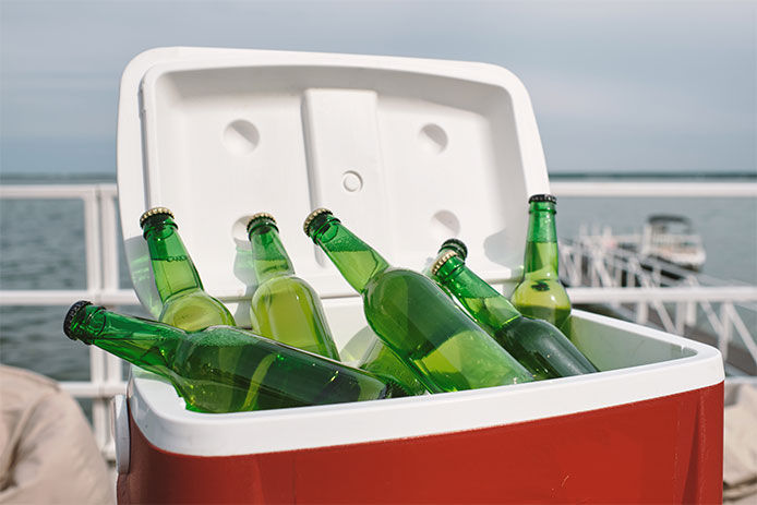 Cooler box with glass of refreshing drinks or beer prepared for birthday party