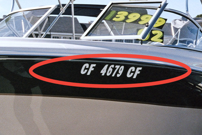 Registration marks on the side of a boat for sale in the marina
