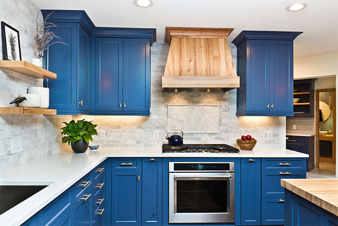 Modern blue cabinetry with white countertops and tile backsplash