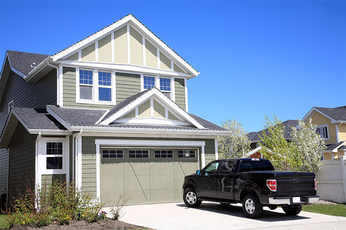 A black pickup truck in the driveway of a house