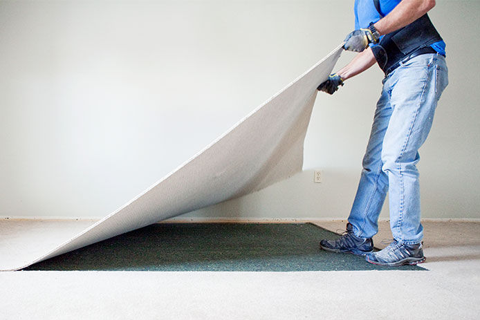 Man pulling up carpet