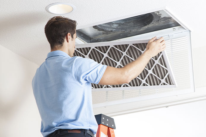 Man cleaning air ducts in home.