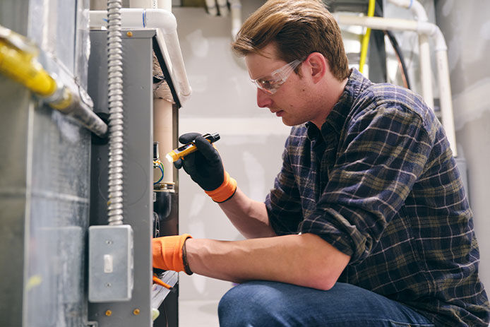 A man inspecting equipment with a flashlight