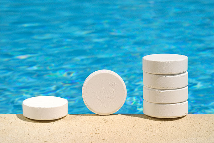 Chlorine tablets sitting on the side of a pool for maintenance and cleaning. These tablets help to sanitize and disinfect the pool water, and are a crucial part of pool upkeep.