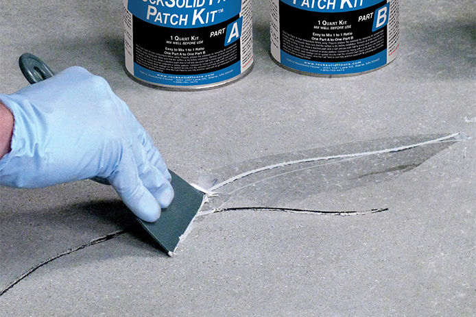 Filling in cracks on a garage floor with concrete filler
