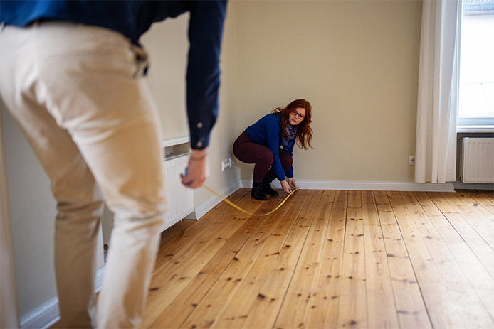 A couple measuring with a tape measure