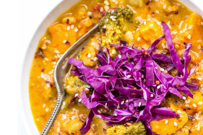 A close up, cropped image of yellow coconut quinoa curry with shredded purple cabbage on top for garnish. 