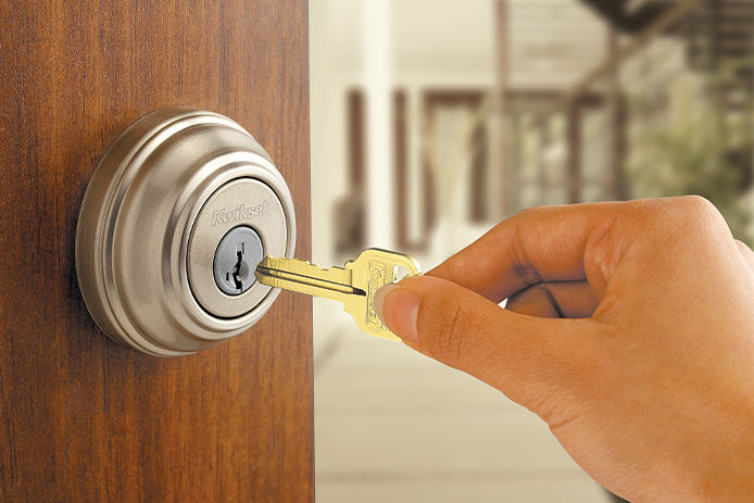 Person placing key inside a deadbolt lock