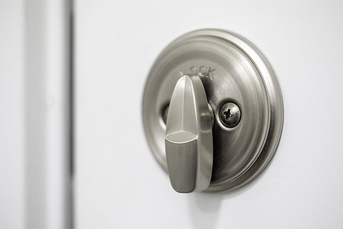 Silver metal deadbolt lock on a white door