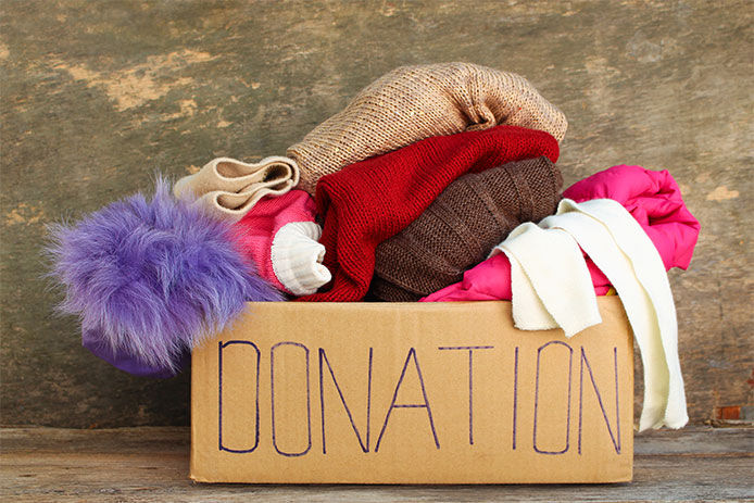 Clothes piled in box with donation written on it