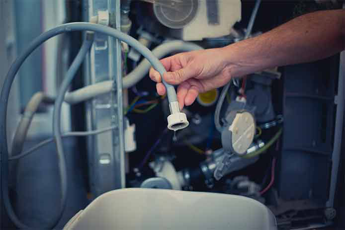 Man tries to repair the leak in a dishwasher line