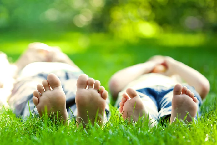 Two people laying in green luscious grass 