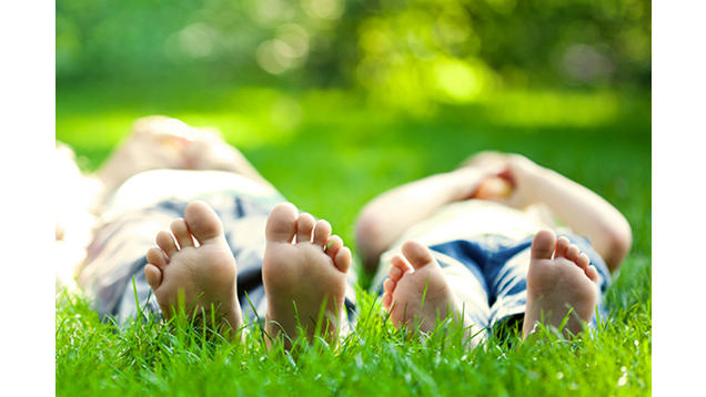 Two people laying in green luscious grass 