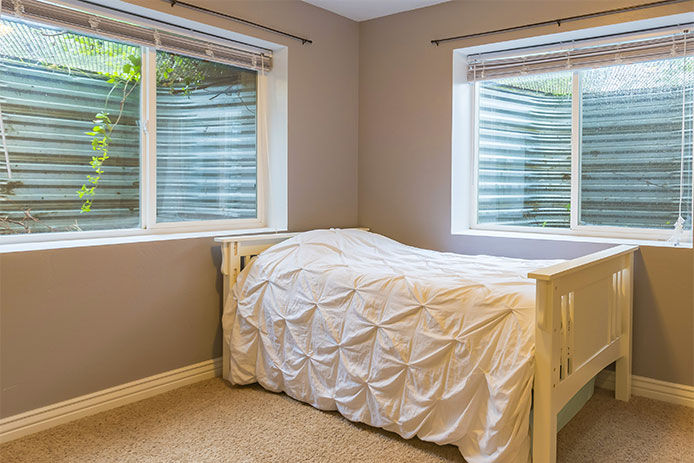 A basement bedroom with two egress windows 