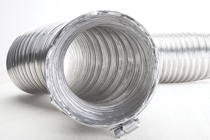 A length of round silver, flexible vent duct tubing rests against a white floor and background.