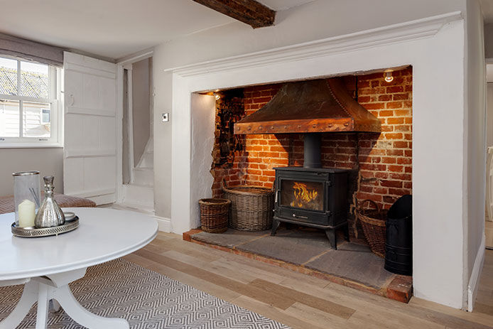 Exposed brick behind the wood burner in a dining/living room