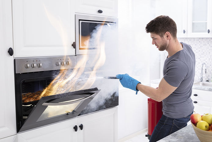 A man extinguishing a fire in the oven