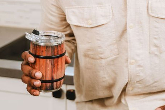 A product lifestyle image of Orca Barrel Insulated Mug being held in a man's hand