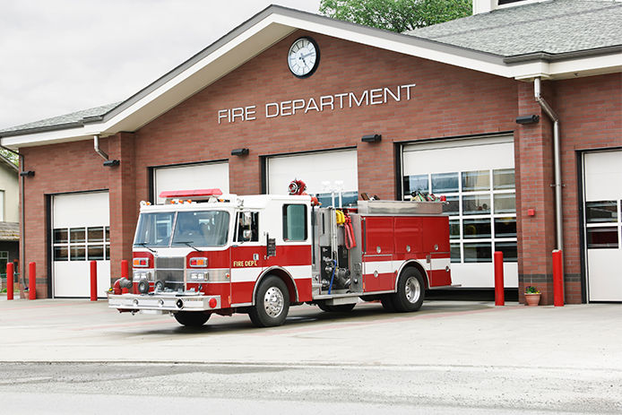 A fire truck in the front of the fire department