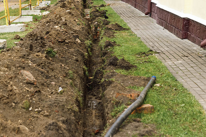 A dirt trench with PVC pipe running through it