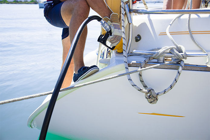 Man refueling yacht on sea gas station