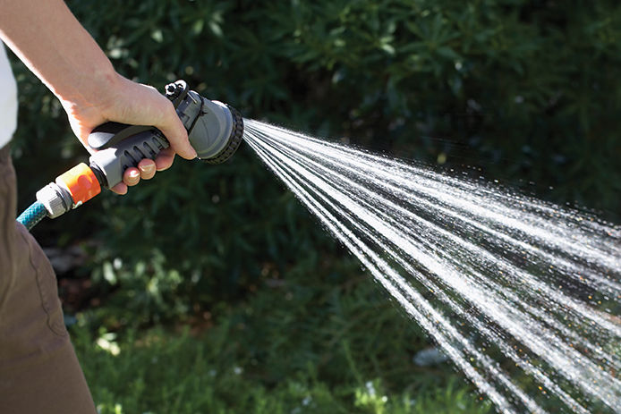 Person spraying a garden hose