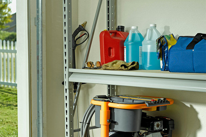 A residential garage with storage unit holding the essential garage supplies from gas cans to windshield washer fluid. 