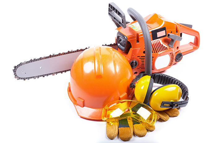 Chainsaw safety gear including helmet, gloves, ear protection and a orange chainsaw