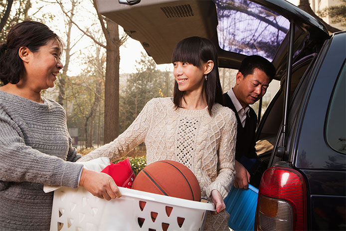 A woman holding a laundry hamper full of things 