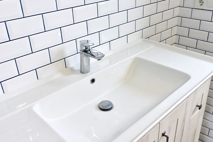 Bathroom sink and white tiled walls