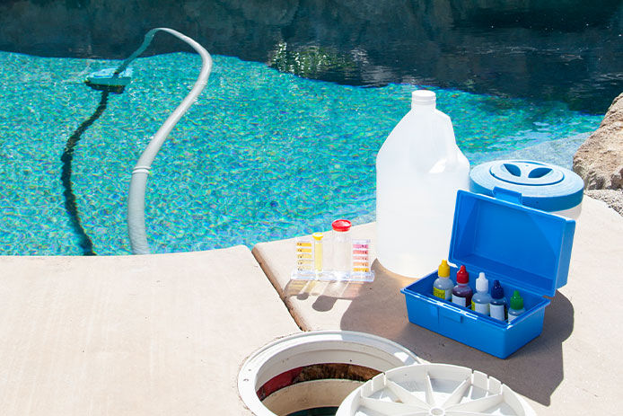 pH testing kit beside a clear pool