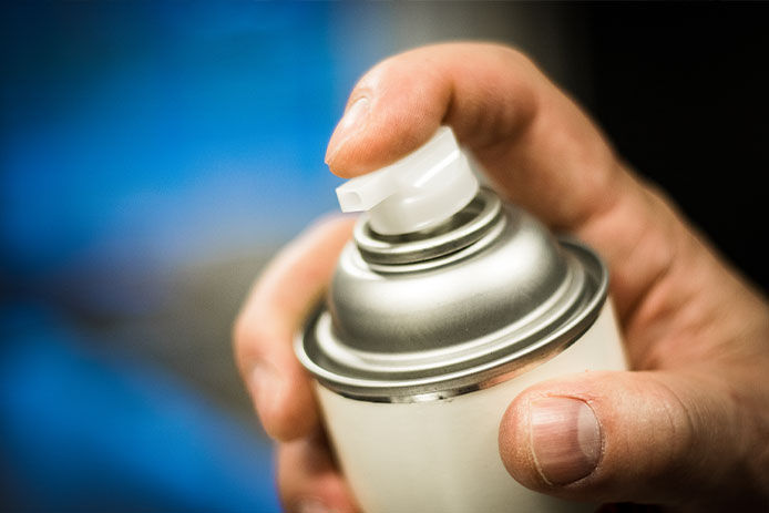 Person getting ready to spray an aerosol can