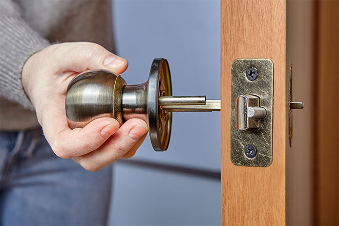 Handyman pushes the door knob spindle through the face bore and the latch assembly