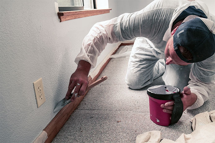 Man painting interior of home in gray paint