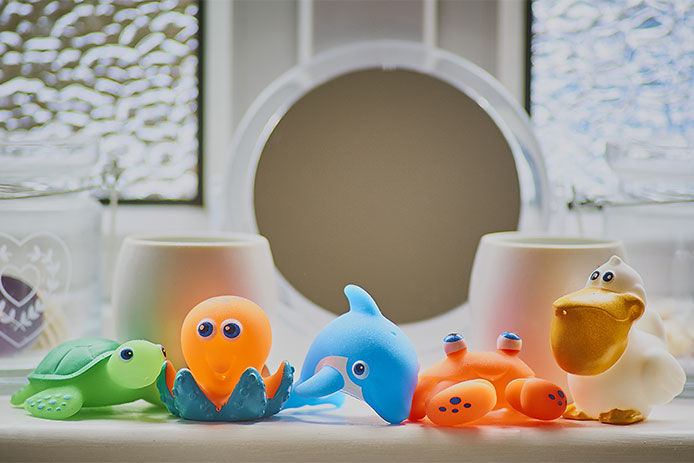 Bath toys all over the bathroom counter 