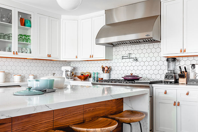A modern kitchen that has wooden accents and subway tile backsplash