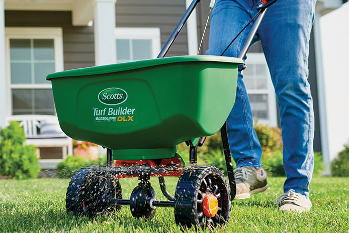 Fertilizing the lawn using a Scotts Turf Builder EdgeGuard DLX Broadcast Fertilizer Spreader