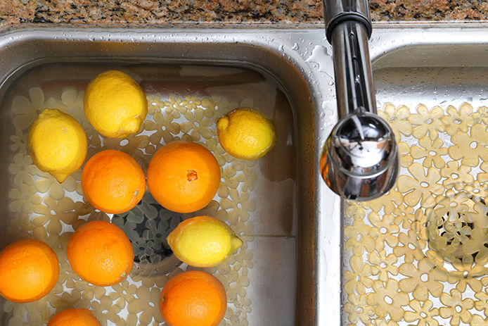 Oranges and lemons in sink filled with water