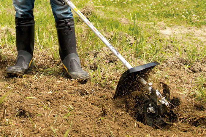  Makita cultivator attachment being used to break up soil