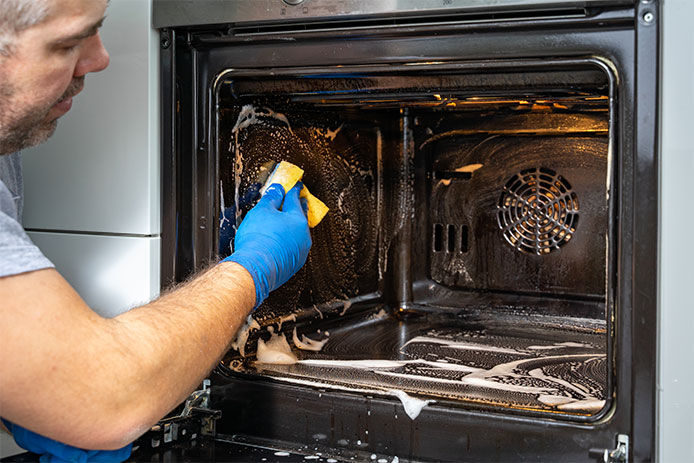 Man cleaning an oven