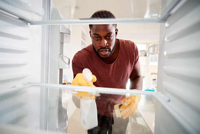 Man cleaning a refrigerator