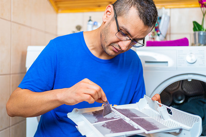 Man peeling the lint from a lint trap