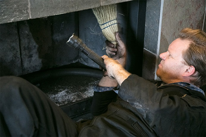 Man looking into a fireplace