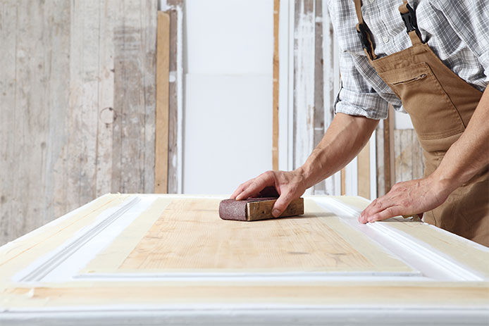 A man sanding a door