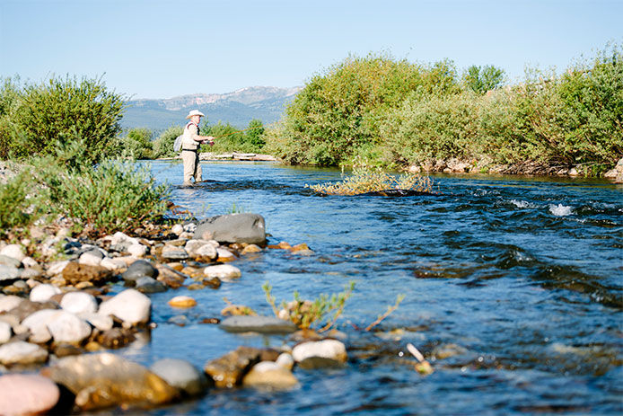 A man casting a fishing line into a river