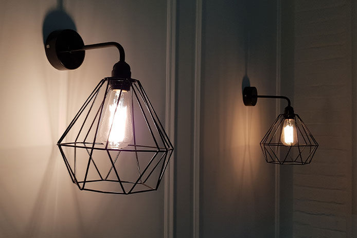 Two black matching sconces in dimmly lit hallway