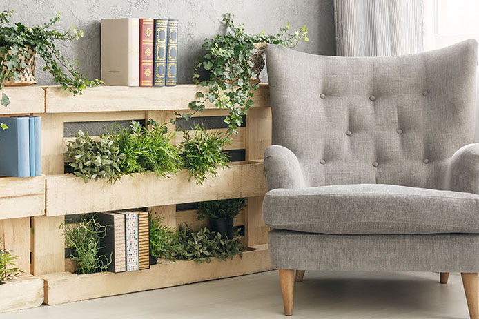 A bookshelf with books and plants made from pallets