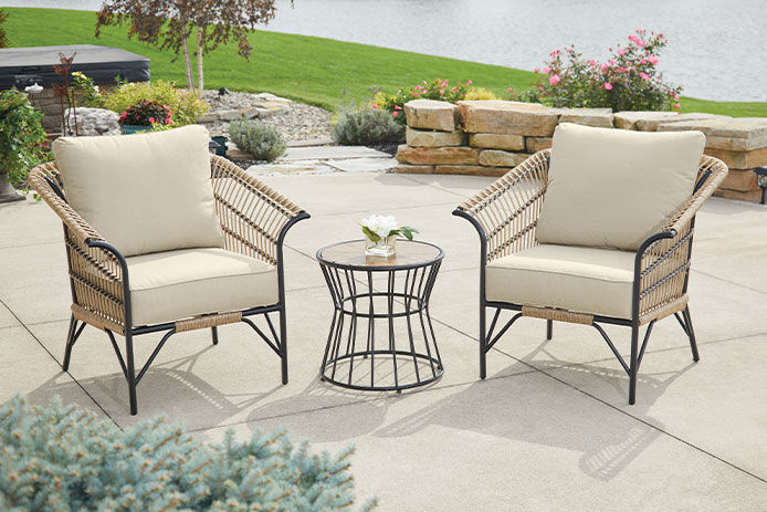 Patio furniture outsid eon the patio with a pond in the background