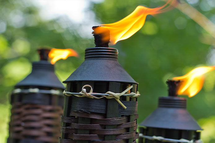 A close-up of tiki torches lit