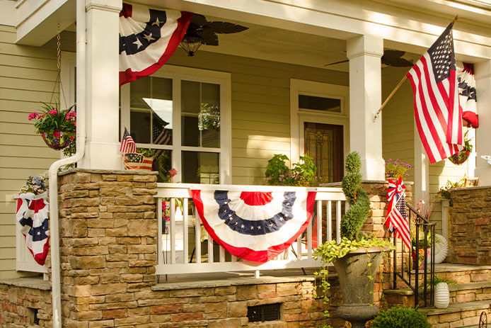 House front porch that is decked out with american flags